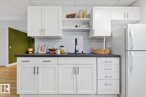 Modern kitchenette featuring white shaker cabinetry, dark countertops, a subway tile backsplash, and a black faucet - 9 Danfield Place, Spruce Grove, AB - Indoor Photo Showing Kitchen