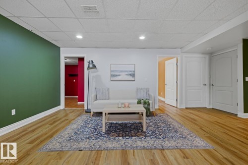 Spacious room featuring wood-finish flooring, recessed lighting, and a white acoustical tile ceiling - 9 Danfield Place, Spruce Grove, AB - Indoor Photo Showing Other Room