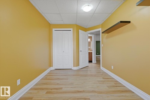 Bedroom featuring wood-finish flooring, bright yellow walls, and white trim - 9 Danfield Place, Spruce Grove, AB - Indoor Photo Showing Other Room