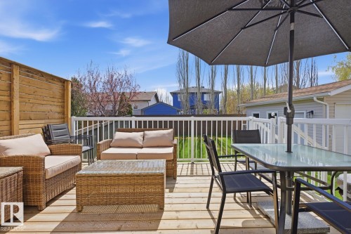 Spacious wood-plank deck featuring a horizontal slat privacy fence and white picket railing - 9 Danfield Place, Spruce Grove, AB - Outdoor With Deck Patio Veranda With Exterior