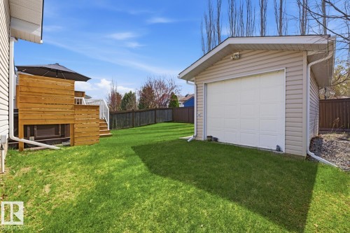 Detached garage featuring siding exterior, white paneled garage door, and a pitched roof - 9 Danfield Place, Spruce Grove, AB - Outdoor With Exterior