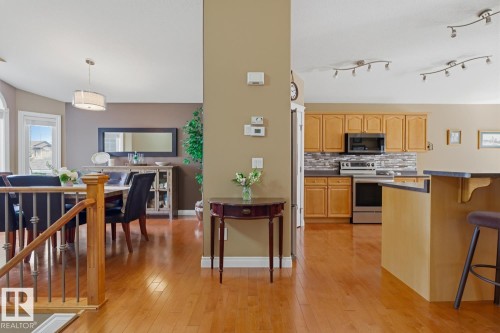 Hardwood-finish flooring extending into kitchen and dining areas - 9 Danfield Place, Spruce Grove, AB - Indoor Photo Showing Kitchen