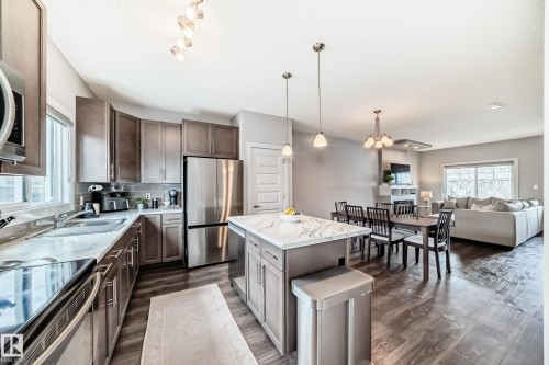 Kitchen featuring an island , stainless steel appliances, wood-finish flooring, and recessed lighting - 6919 Cardinal Wynd, Edmonton, AB - Indoor Photo Showing Kitchen With Stainless Steel Kitchen With Double Sink With Upgraded Kitchen