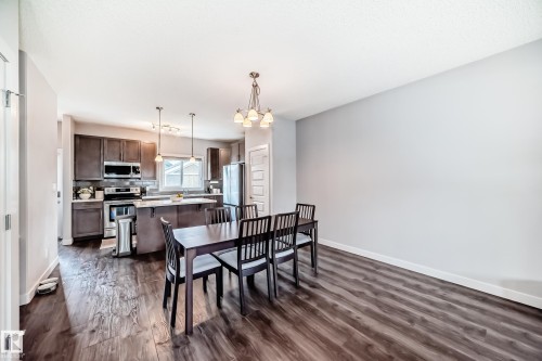 Open-concept kitchen and dining area featuring rich wood-finish flooring - 6919 Cardinal Wynd, Edmonton, AB - Indoor