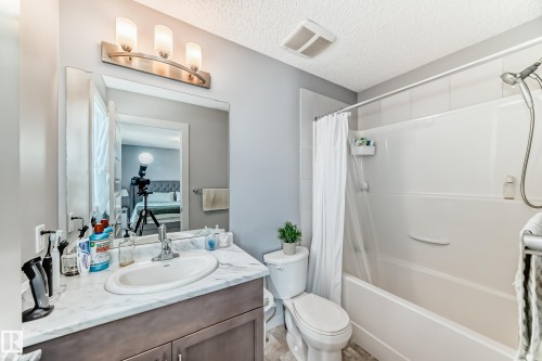 Bathroom featuring a vanity with an integrated sink, a white countertop, and under-sink cabinetry - 6919 Cardinal Wynd, Edmonton, AB - Indoor Photo Showing Bathroom