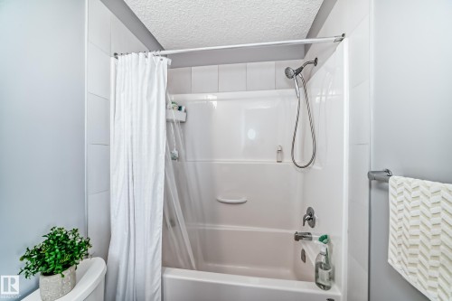 Bathroom featuring a white tub-shower combination with a chrome showerhead - 6919 Cardinal Wynd, Edmonton, AB - Indoor Photo Showing Bathroom