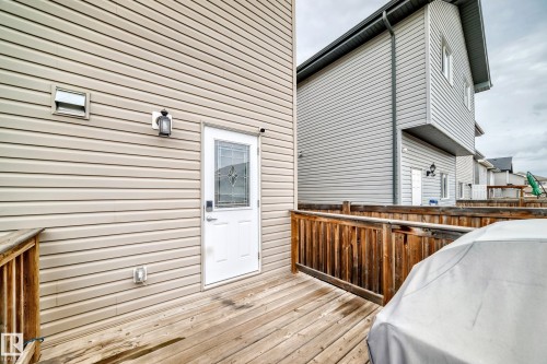 Outdoor wood-finish deck featuring a wood railing and light-colored horizontal siding - 6919 Cardinal Wynd, Edmonton, AB - Outdoor With Deck Patio Veranda With Exterior