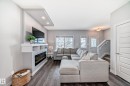 Spacious living area featuring an integrated media wall with an electric fireplace, recessed lighting, and shelving - 6919 Cardinal Wynd, Edmonton, AB  - Indoor Photo Showing Living Room With Fireplace 