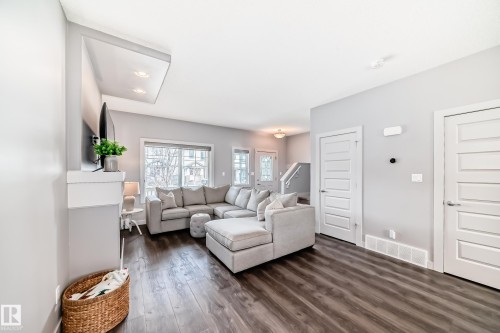 Spacious living area featuring wood-finish flooring, recessed lighting, and a window with natural light - 6919 Cardinal Wynd, Edmonton, AB - Indoor Photo Showing Living Room