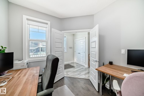 Room featuring wood-finish flooring, light grey painted walls, and white trim - 3716 46 Avenue, Beaumont, AB - Indoor Photo Showing Office