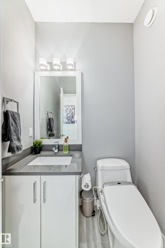 Modern vanity featuring a rectangular under-mount sink set into a dark gray countertop - 3716 46 Avenue, Beaumont, AB - Indoor Photo Showing Bathroom