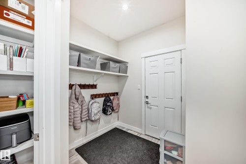 Entryway featuring a white paneled door, light-colored wood-finish flooring, and a dark floor mat - 3716 46 Avenue, Beaumont, AB - Indoor Photo Showing Other Room