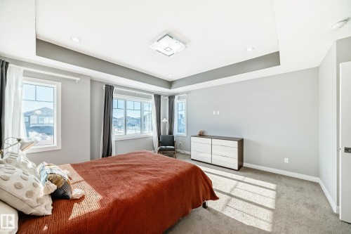 Bedroom featuring a tray ceiling with recessed lighting and a central flush-mount fixture - 3716 46 Avenue, Beaumont, AB - Indoor Photo Showing Bedroom