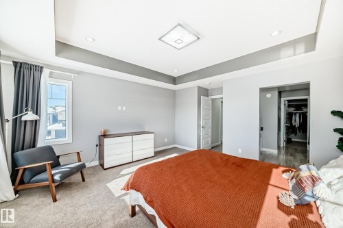 Spacious room featuring a tray ceiling with recessed lighting and a central flush-mount fixture - 3716 46 Avenue, Beaumont, AB - Indoor Photo Showing Bedroom