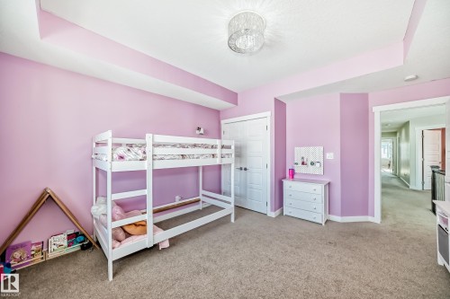Bedroom with textured carpet, white baseboards, and a contemporary ceiling light fixture - 3716 46 Avenue, Beaumont, AB - Indoor Photo Showing Bedroom