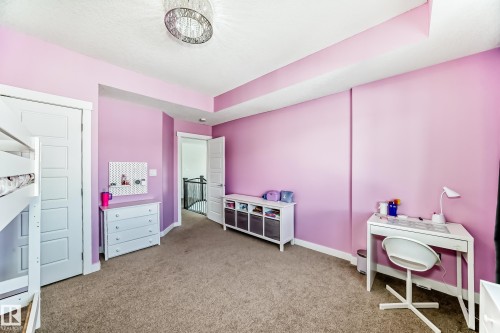 Carpeted room featuring a drop ceiling detail and a chandelier light fixture - 3716 46 Avenue, Beaumont, AB - Indoor Photo Showing Bedroom