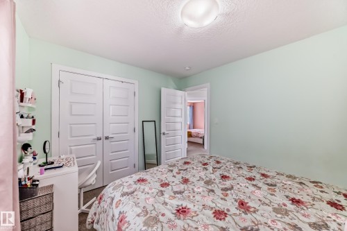 Interior room featuring light green walls, a semi-flush mount ceiling light, and a white six-panel closet door - 3716 46 Avenue, Beaumont, AB - Indoor Photo Showing Bedroom