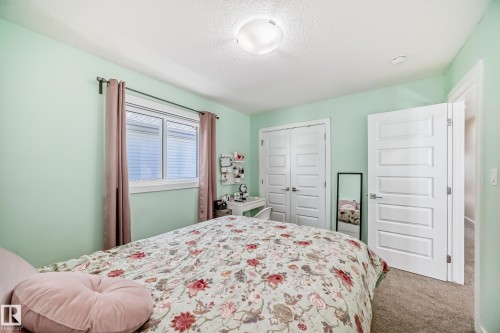 Bedroom featuring mint green walls, a single window with blinds, carpet flooring, a flush mount ceiling light, and white paneled doors - 3716 46 Avenue, Beaumont, AB - Indoor Photo Showing Bedroom