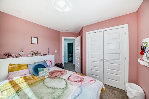 Bedroom featuring a ceiling-mounted light fixture, white trim, and a doorway leading to an additional space - 3716 46 Avenue, Beaumont, AB - Indoor Photo Showing Bedroom