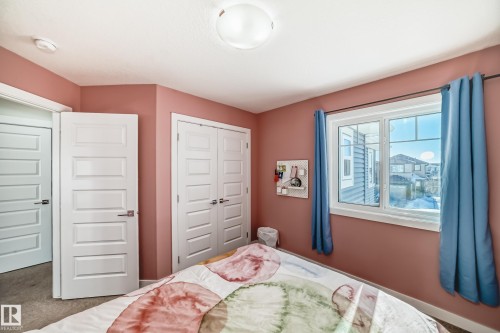 Bedroom featuring a double-pane window, flush-panel interior doors, and a double-door closet - 3716 46 Avenue, Beaumont, AB - Indoor Photo Showing Bedroom