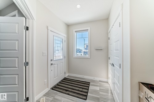 Entryway featuring tile flooring, a front door with decorative glass, a window, and recessed lighting - 3716 46 Avenue, Beaumont, AB - Indoor Photo Showing Other Room