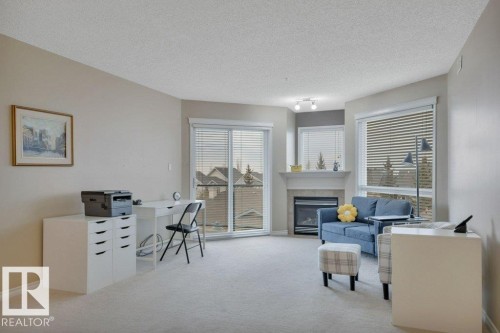 302 102A Bridgeport Crossing, Leduc, AB - Indoor Photo Showing Other Room With Fireplace