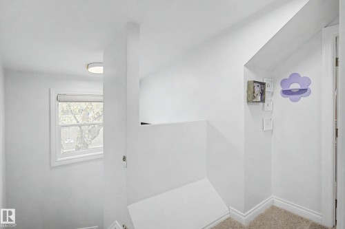 Upper-level hallway with neutral carpeting, white trim, and a white interior door - 13316 109A Avenue, Edmonton, AB - Indoor Photo Showing Other Room