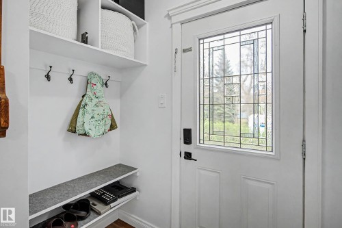 White entry door featuring leaded glass paneling with a smart lock system - 13316 109A Avenue, Edmonton, AB - Indoor Photo Showing Other Room