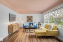 Spacious living area featuring wood-finish flooring, large picture windows, and a tray ceiling - 13316 109A Avenue, Edmonton, AB  - Indoor Photo Showing Living Room 