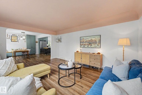 Open-concept living space featuring wood-finish flooring, white walls, and a pink ceiling detail - 13316 109A Avenue, Edmonton, AB - Indoor Photo Showing Living Room