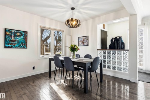 Dining area featuring wood-finish flooring, a large window, and an overhead pendant light fixture - 14608 97 Avenue, Edmonton, AB - Indoor Photo Showing Dining Room