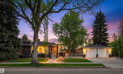 Contemporary ranch-style residence featuring a stone and wood facade, a two-car garage with individual doors, a paved driveway, and mature landscaping - 14608 97 Avenue, Edmonton, AB - Outdoor