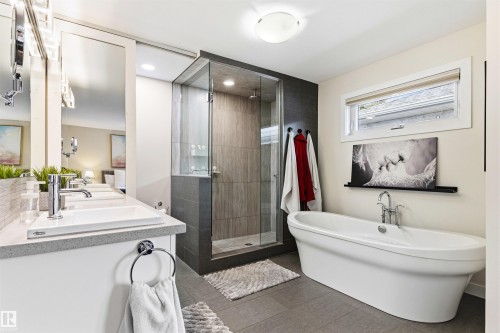 Contemporary bathroom featuring a freestanding soaking tub, an enclosed shower with glass door, a double vanity with undermount sinks, and a horizontal window - 14608 97 Avenue, Edmonton, AB - Indoor Photo Showing Bathroom