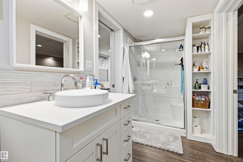White vanity with shaker-style cabinetry, a vessel sink, and a chrome faucet - 14608 97 Avenue, Edmonton, AB - Indoor Photo Showing Bathroom