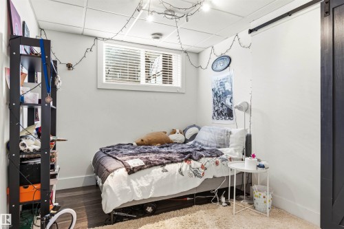 Compact room featuring dark wood-finish flooring, light grey walls, and a white drop ceiling - 14608 97 Avenue, Edmonton, AB - Indoor Photo Showing Bedroom