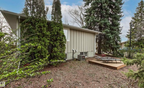 Exterior siding with mature landscaping and a ground-level wood deck - 14608 97 Avenue, Edmonton, AB - Outdoor