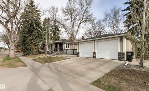 Two-car detached garage with white overhead doors and stone veneer accents - 14608 97 Avenue, Edmonton, AB - Outdoor