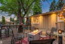 Expansive outdoor deck featuring wood flooring, a built-in fire pit, string lighting, and direct exterior access - 14608 97 Avenue, Edmonton, AB  - Outdoor With Deck Patio Veranda 