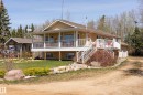 Elevated ranch-style home featuring a wraparound covered porch, multiple upper-level access points, and a full-height lower level with visible windows - 77 Lakeshore Drive, Rural Leduc County, AB  - Outdoor With Deck Patio Veranda 