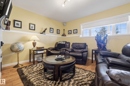 Lower-level living area featuring wood-finish flooring, light-colored walls, and a multi-pane window - 77 Lakeshore Drive, Rural Leduc County, AB - Indoor