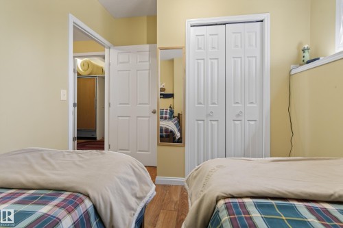 Room featuring wood-finish flooring, light yellow walls, and white trim - 77 Lakeshore Drive, Rural Leduc County, AB - Indoor Photo Showing Bedroom