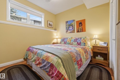 Bedroom featuring wood-finish flooring, a baseboard trim, and a window with a white frame - 77 Lakeshore Drive, Rural Leduc County, AB - Indoor Photo Showing Bedroom