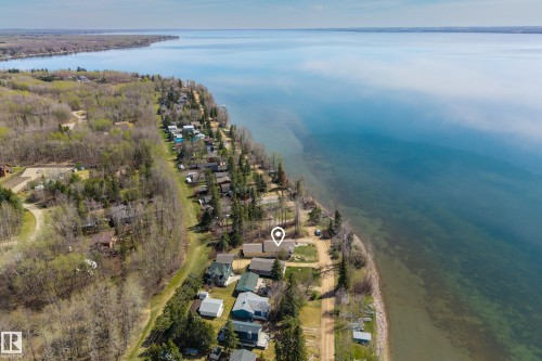 Waterfront property featuring extensive shoreline frontage, mature tree cover, and direct water access - 77 Lakeshore Drive, Rural Leduc County, AB - Outdoor With Body Of Water With View