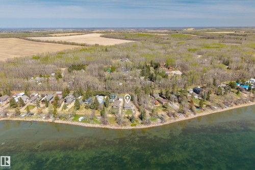 Waterfront property with extensive shoreline, surrounded by mature trees - 77 Lakeshore Drive, Rural Leduc County, AB - Outdoor With Body Of Water With View