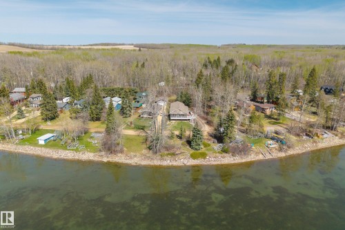 Waterfront property with multiple residential structures, mature trees, and direct water access - 77 Lakeshore Drive, Rural Leduc County, AB - Outdoor With Body Of Water With View
