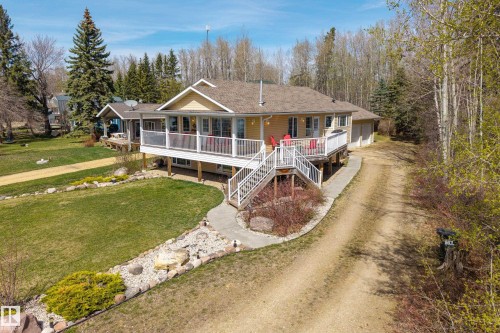 Ranch-style residence featuring a prominent elevated deck with white railings and dual staircases - 77 Lakeshore Drive, Rural Leduc County, AB - Outdoor With Deck Patio Veranda