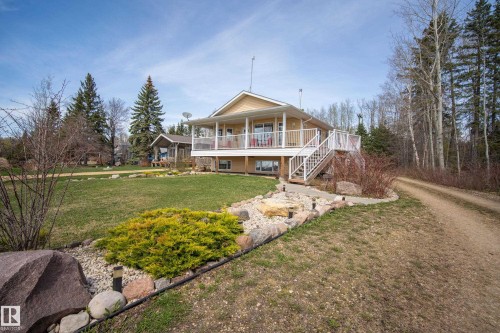 Raised home with a large deck, white railings, and an exterior staircase - 77 Lakeshore Drive, Rural Leduc County, AB - Outdoor