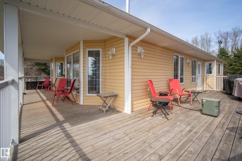 Expansive outdoor decking features a covered porch area with white railings and an exposed sun deck - 77 Lakeshore Drive, Rural Leduc County, AB - Outdoor With Deck Patio Veranda With Exterior