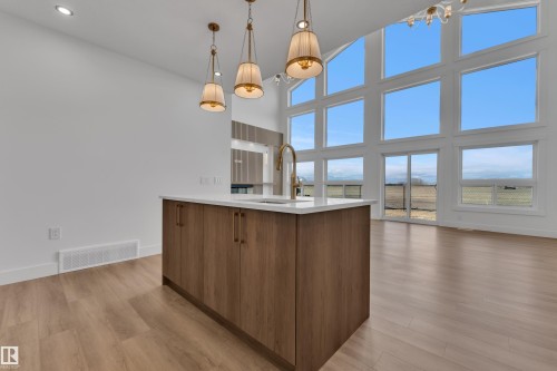 Kitchen island featuring wood-finish cabinetry, a white countertop, and a gooseneck faucet - 13128 187 Avenue, Edmonton, AB - Indoor Photo Showing Kitchen
