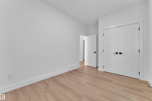 Neutral interior featuring light wood-finish flooring, white walls, and a closet with double panel doors - 13128 187 Avenue, Edmonton, AB - Indoor Photo Showing Other Room